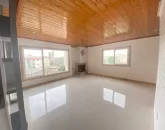 نمای داخلی اتاق نشیمن و پنجره های نورگیر و سقف چوبی آپارتمان 85 متری 2 خوابه خوش ساخت در محمودآباد 4154156312