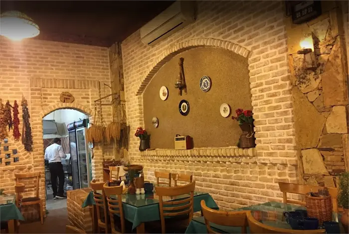رستوران سنتی آسو با نمایی از دیوار های آجری و میز وصندلی های چیده شده 16654654